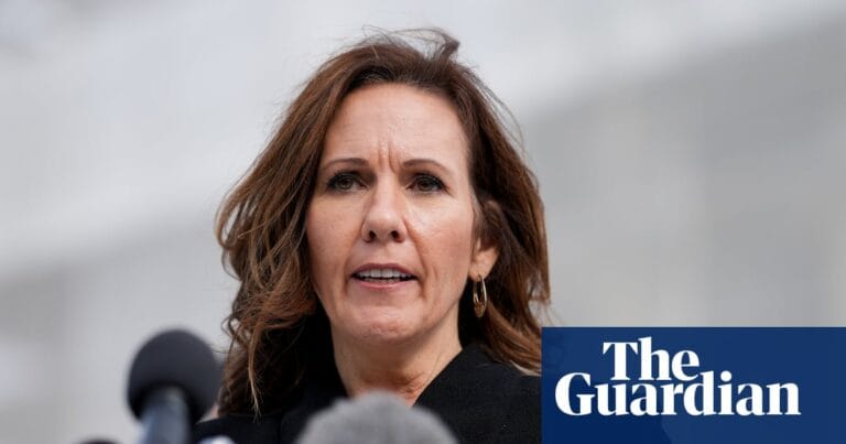 Liberty Justice Center CEO Sara Albrecht在户外新闻发布会上发言，背景为麦克风（Guardian配图，摄影：Bloomberg/Getty Images）。
