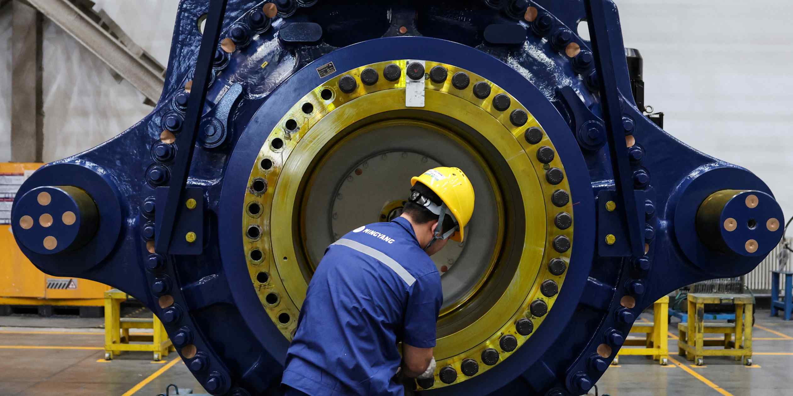 中国内蒙古工人正在组装风力涡轮发电机，象征工业产出韧性
