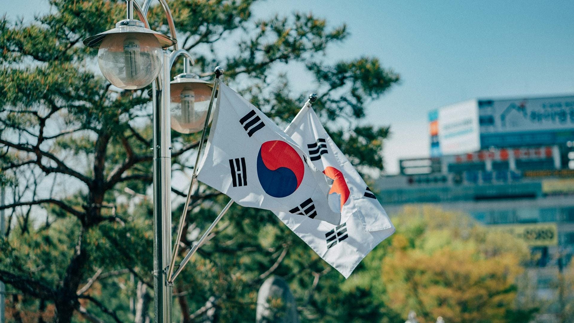韩国 KOSPI 指数两日暴跌与比特币价格走势叠加的跨资产对比图,标注 BTC 同期上行至约 63800 美元、未跟随芯片股回落