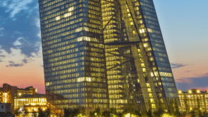夜晚灯光下的欧洲央行（ECB）总部大楼，象征欧盟监管机构对稳定币收益规则的收紧。