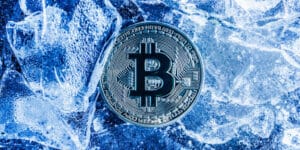 特勤局冻结USDT资金的概念示意图，金色加密硬币悬浮在冰面之上
