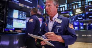 纽约证券交易所交易大厅内，交易员在AI与芯片股反弹期间交易
