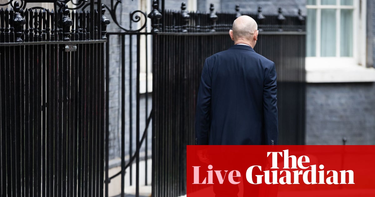 英国财政大臣约翰·希利在唐宁街手持预算文件箱,用于说明本文分析的英国预算争议